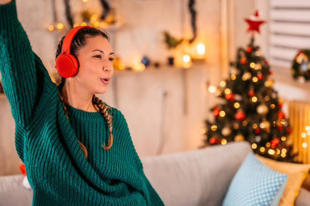 istock Woman singing and dancing at home at Christmas 1354867754