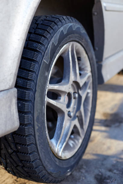 istock Silver car and wheel with winter rubber studded 1354868863