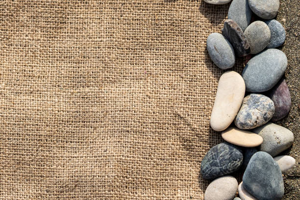 istock Burlap fabric and beach stones 1354868987
