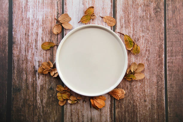 istock Decorative ceramic beige plate and yellow leaves 1354869362