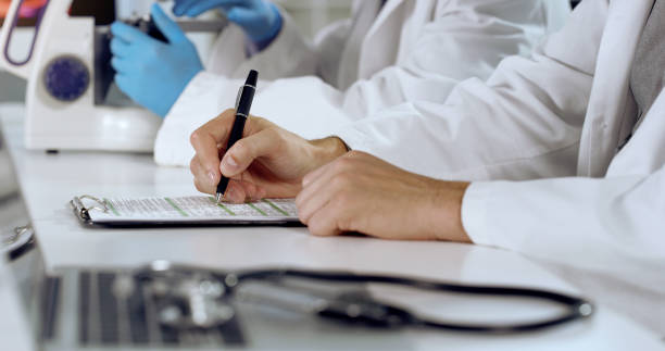 istock Shot of an unrecognizable person writing on a form at work 1354871099