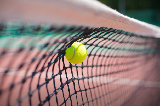 istock Tennis ball hits in the net during game. 1354874004