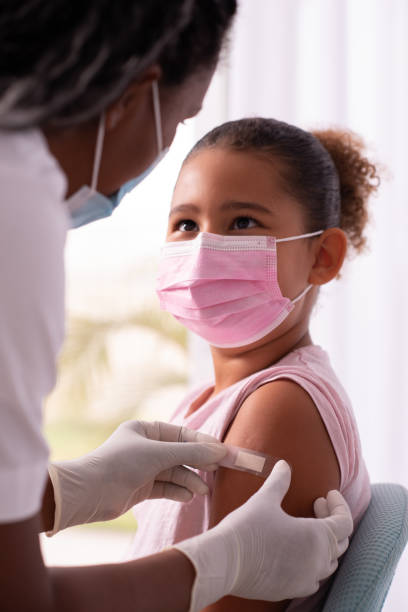 Doctor putting plaster at child's hand after injection of a covid-19 vaccine. Medical healthcare worker putting a bandage on the child's arm after covid-19 vaccination. herd immunity photos stock pictures, royalty-free photos & images