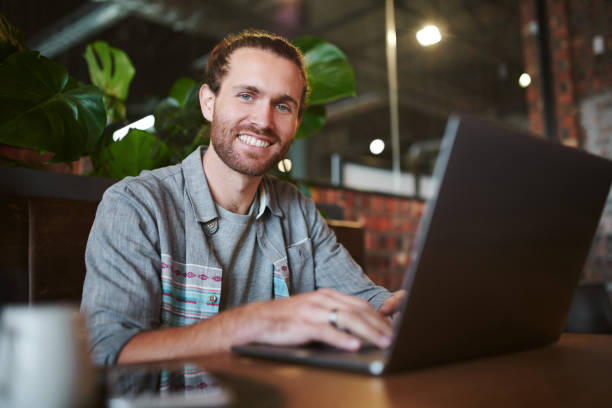 istock Shot of a young businessman teleworking from a cafe while using his laptop 1354875968