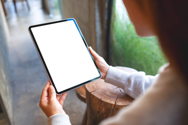 istock a woman holding digital tablet with blank white desktop screen 1354876032