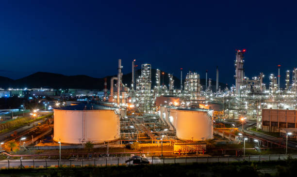 vista aérea. fábrica de refinería de petróleo y tanque de almacenamiento de petróleo en el crepúsculo y la noche. petroquímica industrial. - central eléctrica fotografías e imágenes de stock