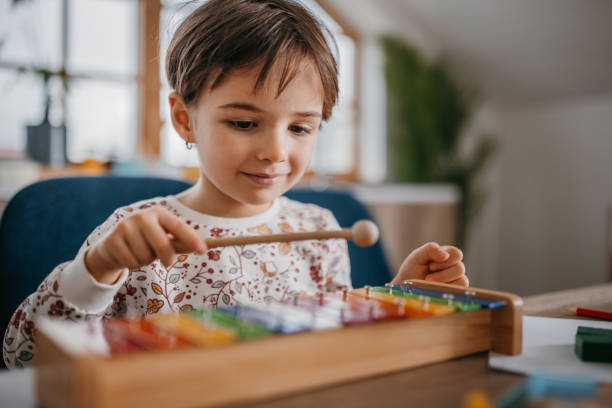 One girl, little girl is playing with xylophone at home.