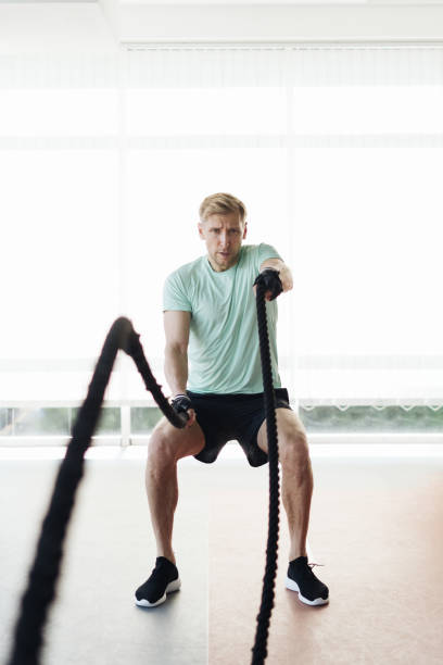 istock Young athlete man is training with rope in a space with a lot of light 1354880091