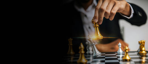 ワイドバナー。チェスボードゲーム競技、チェスの戦い、経営、リーダーシップの成功、チームリーダー、チームワーク、ビジネス戦略計画コンセプトで金色のチェスを動かすビジネスマン� - risk board game board game victory war ストックフォトと画像