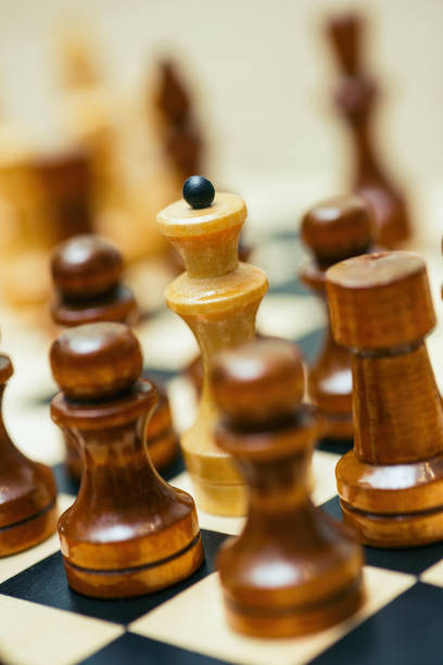 istock chess pieces stand on a chessboard. Pawns surrounded the queen 1354881025