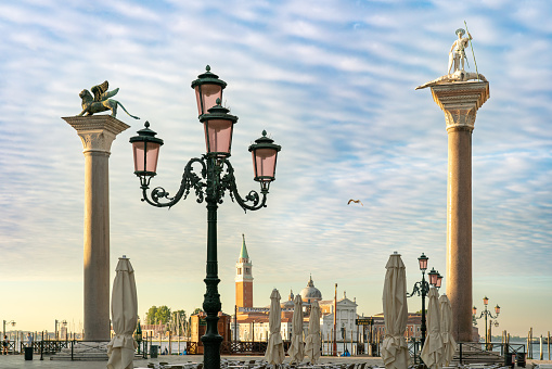 Serene early summer morning at Piazzetta San Marco in Venice, Italy with columns of the Lion of Venice and St Theodore, with San Giorgo Maggiore in the background