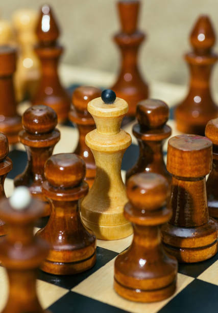 istock chess pieces stand on a chessboard. Pawns surrounded the queen 1354882167