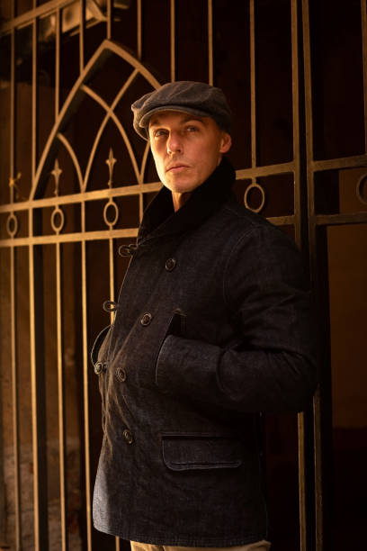 istock A man in a coat and cap walks around the city. 1354885866