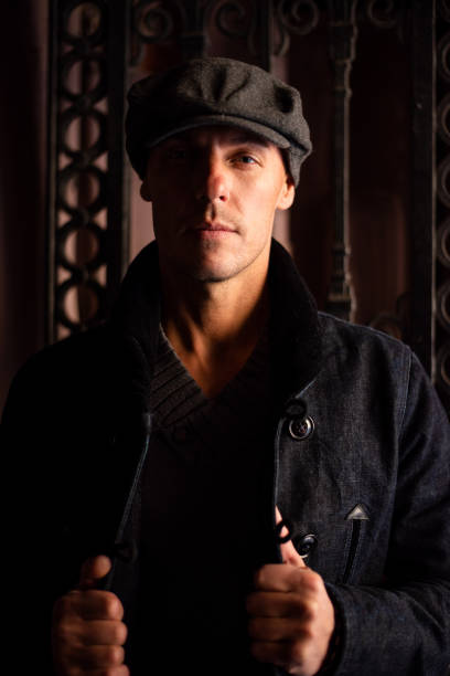 istock A man in a coat and cap walks around the city. 1354885922