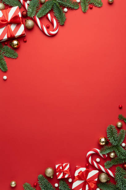 istock Christmas frame for text with fir decorations and gifts on red background 1354886092
