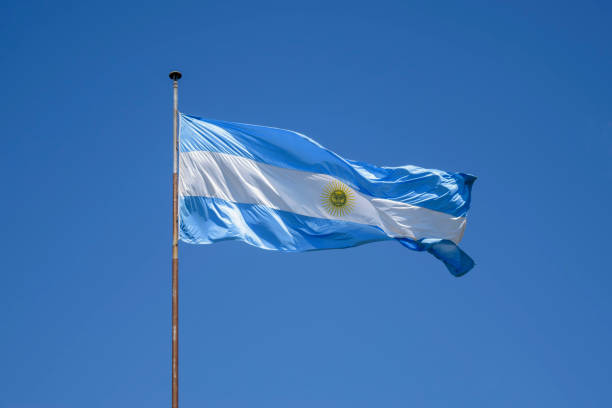 istock Argentine national flag on mast fluttering over blue sky 1354886795