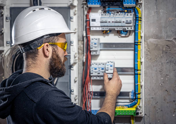 istock A male electrician works in a switchboard with an electrical connecting cable. 1354891287