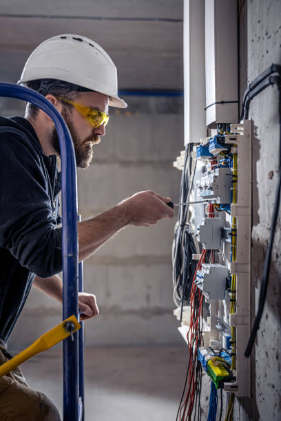 istock A male electrician works in a switchboard with an electrical connecting cable. 1354891325