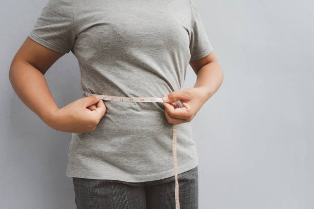 istock fat woman measuring her fat belly. 1354891667