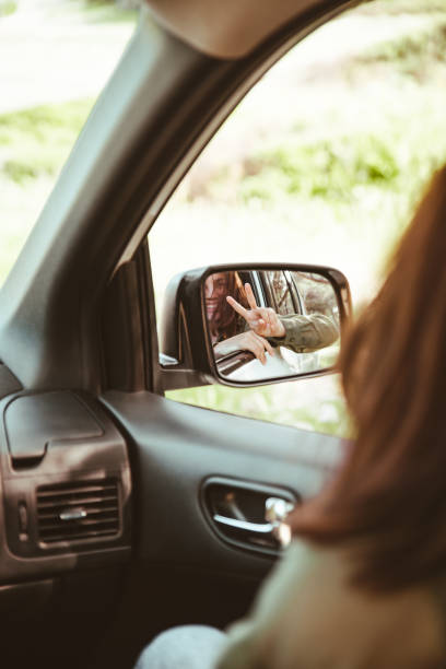 istock reflection on stunning smiling woman in car rear mirror 1354892341