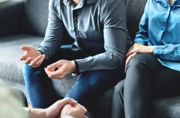 Photo of Mediator or family counsel with couple in therapy meeting. Divorce lawyer, marriage counselor, psychologist or doctor interview upset man and woman. Sad people with anxiety.