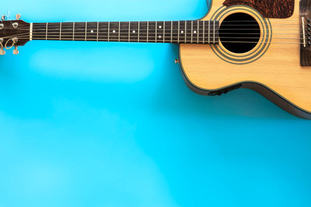 istock Acoustic guitar on a blue background, top view, copy space. 1354895042