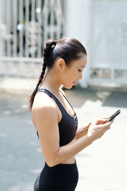 istock Female Jogger Checking her Phone 1354895329