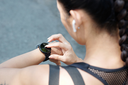 Female jogger checking map on smartwatch when runnning outdoors in the morning