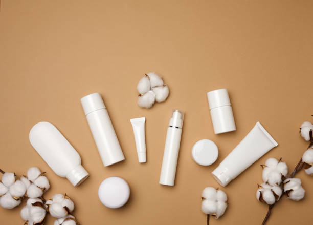 istock jar, bottle and empty white plastic tubes for cosmetics on a beige background. Packaging for cream, gel, serum, advertising and product promotion, mock up, top view 1354897121
