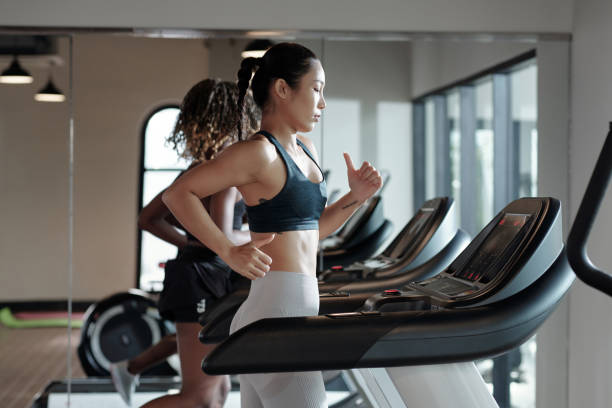 istock Young Woman Jogging on Treadmill 1354897288