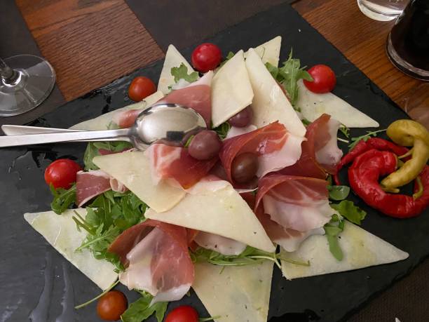 istock Appetizer Plate Cheese Truffle TomatoEs Ham Olives Arugula 1354898339