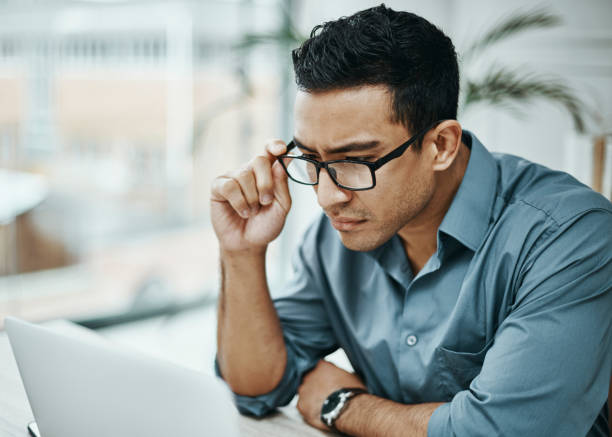 istock Shot of a young businessman using a laptop in a modern office 1354898595