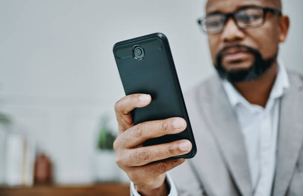 istock Shot of a mature businessman using a smartphone in a modern office 1354898652