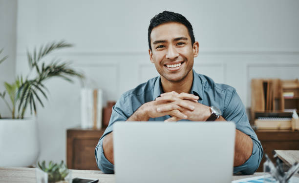 istock Shot of a young businessman using a laptop in a modern office 1354898756