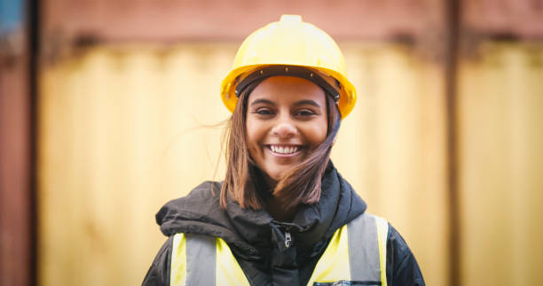 Shot of a young woman wearing a hardhat at work stock photo