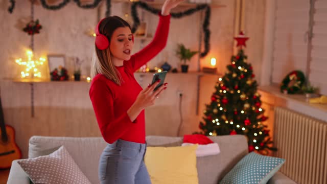Woman singing and dancing at home at Christmas