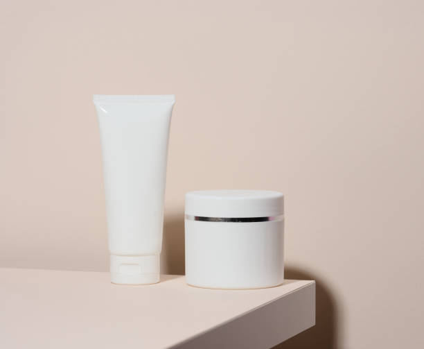 istock empty white plastic tube andjar for cosmetics stands on a beige background. Containers for cream, shampoos, liquid substances. Branding, template 1354902055