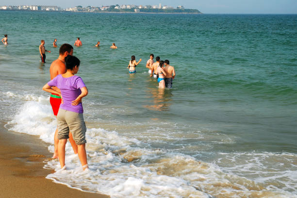 Hampton Beach, NH, USA July 15 An adult couple enjoys wading in the ocean waters near Hampton Beach, New Hampshire on a summer day