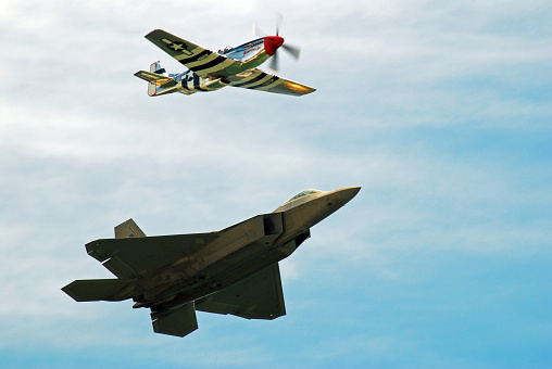 Wantagh, NY, USA May 23 An F-22 Raptor twin jet engine and a World War II era P 51 Mustang share the skies over Wantagh New York