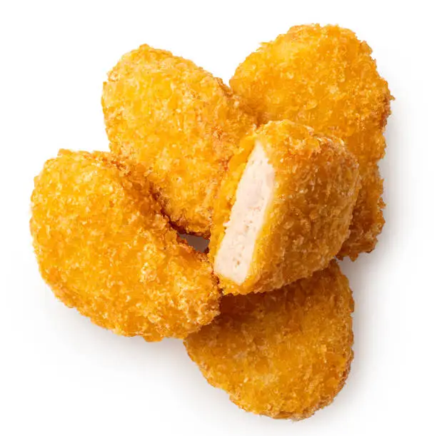 Pile of fried gluten free cornflake crumb chicken nuggets isolated on white. One cut. Top view.