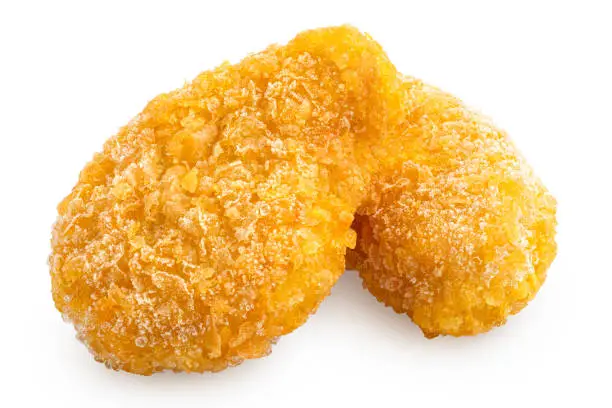 Two frozen gluten free cornflake crumb chicken nuggets isolated on white.