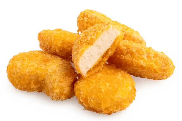 Pile of fried gluten free cornflake crumb chicken nuggets isolated on white. One cut.