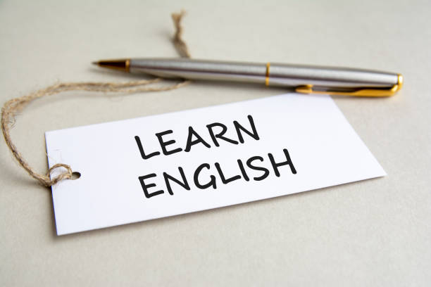 istock card with text Learn English with metal pen on gray background 1354906631