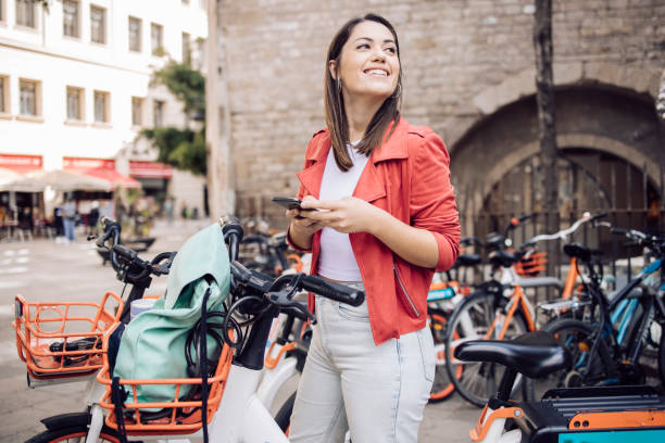 Young female tourist renting an e-bike to explore Barcelona Young female tourist renting an e-bike to explore Barcelona. rent a bike stock pictures, royalty-free photos & images