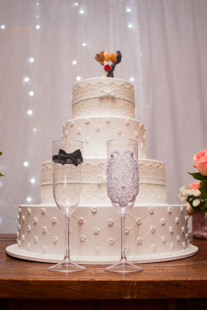 istock Wedding cake with newlyweds on top and cups 1354907186