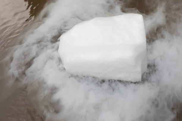 Dry ice evaporates in the water. Steam from a large piece of ice. Chemical experiment. stock photo