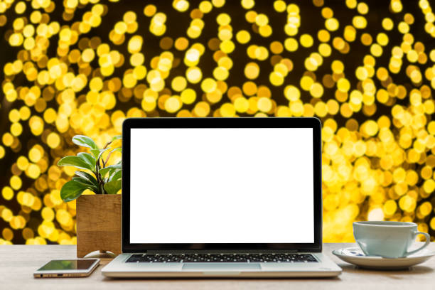istock laptop computer with empty White screen with smartphone and coffee cup  on table Yellow Colorful light Abstract circular bokeh of Christmas tree background Decoration During Christmas and New Year 1354908707