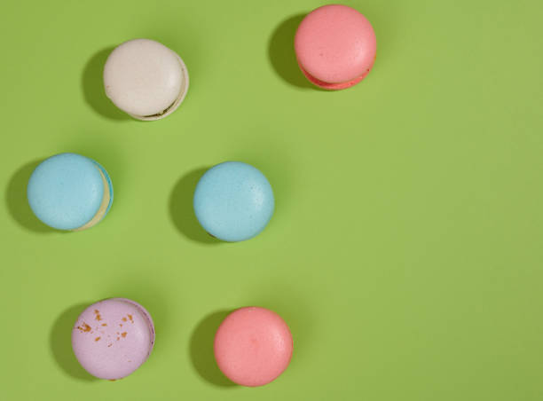 istock baked macarons with different flavors on a green background, top view 1354909355