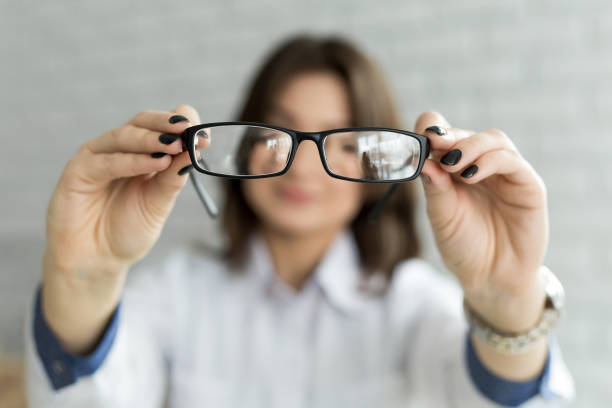 istock Close up female hands holding eyeglasses. Ophthalmology concept 1354909398