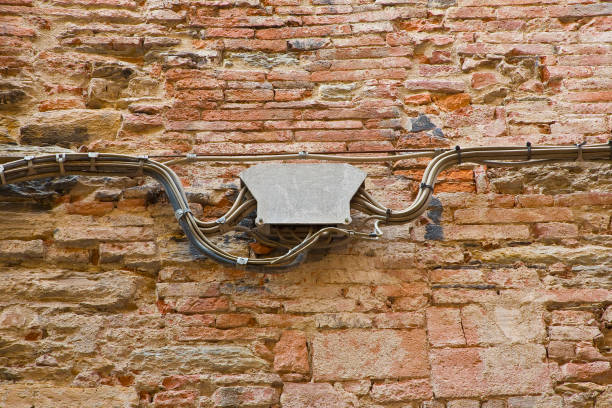 Metal electrical junction box against a brick wall for external electric plant